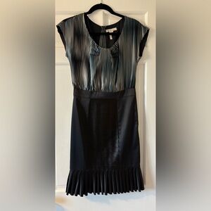Black, silver, and blue striped dress with pleated skirt. Knee length,side zip.